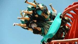 close up of people aboard Mind Eraser ride with blue sky in background at Elitch Gardens in Denver, Colorado, USA